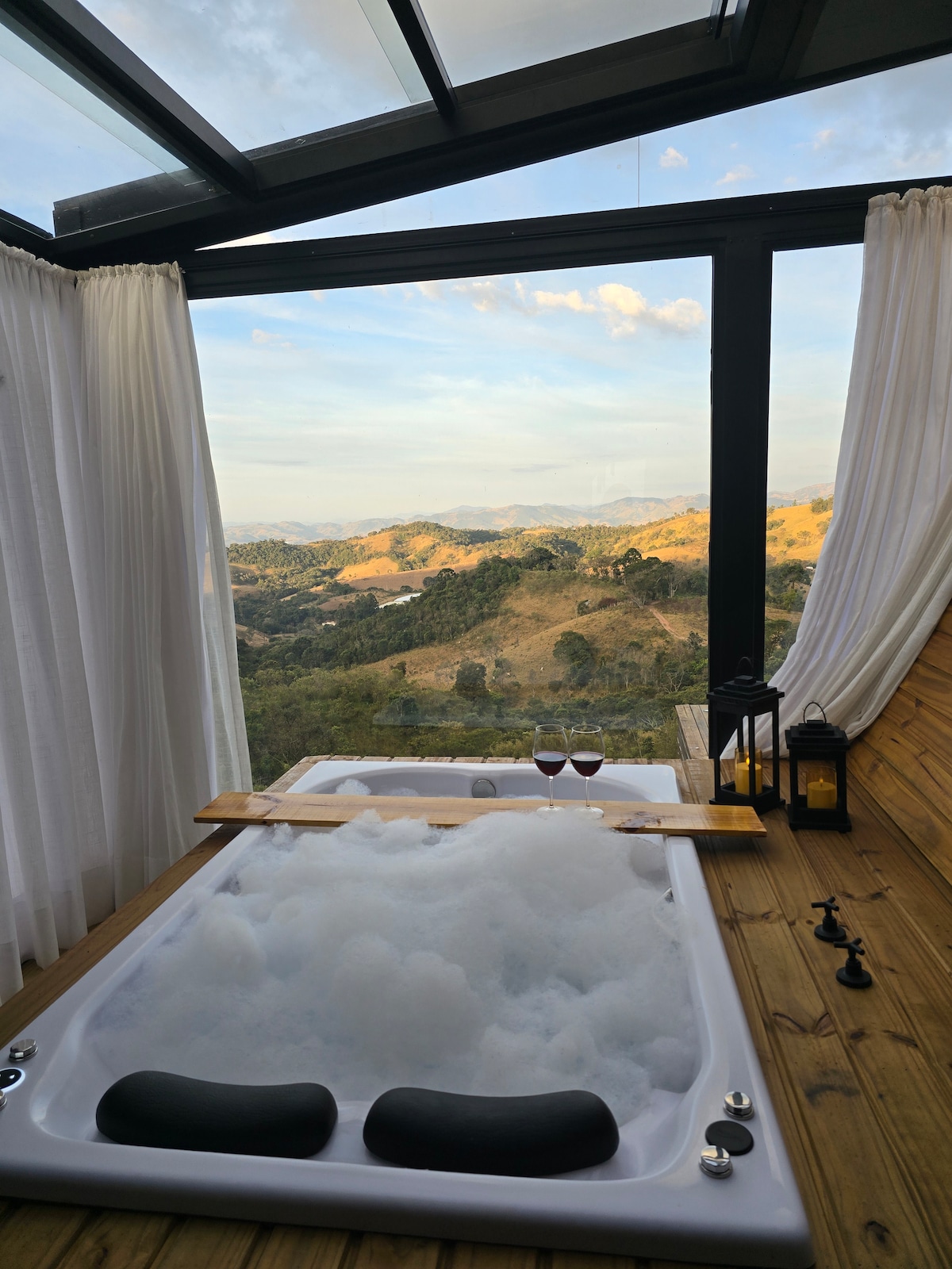 Banheira de hidromassagem de dia, teto aberto e cortinas brancas